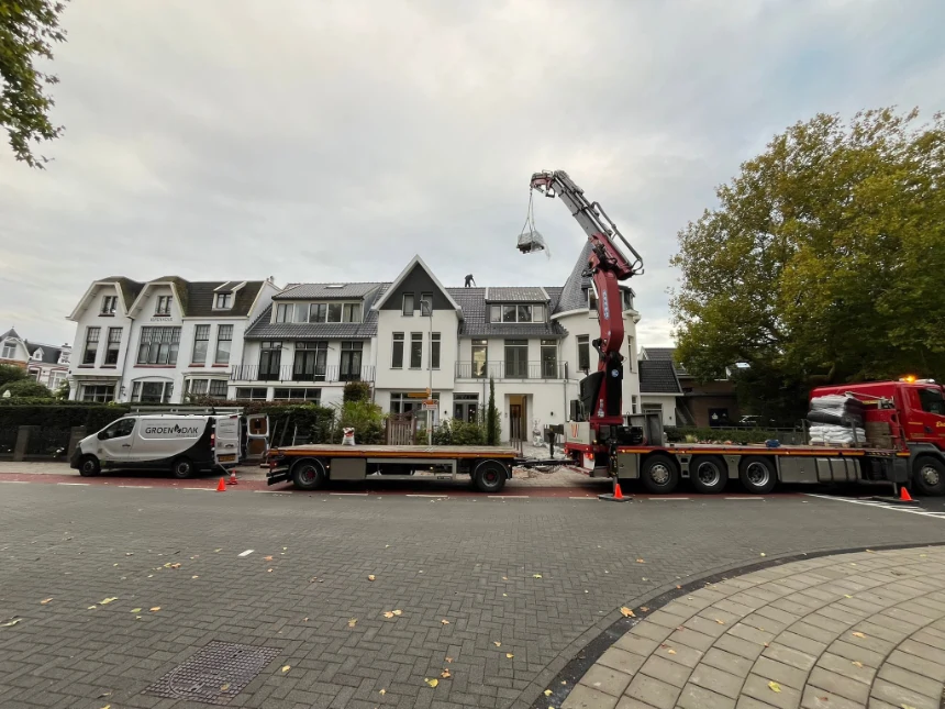 Groendakspecialist met kraanwagen voor aanleg van een groen dak