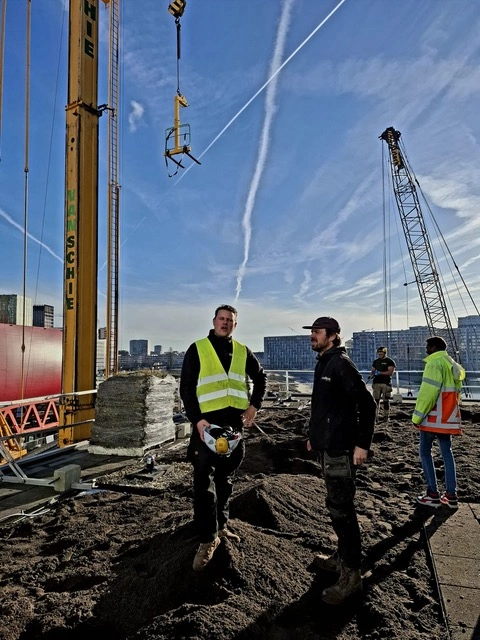 Eigenaar Gert van de Groendakspecialist staat samen met Roderick op een hoog dak waar ze een groendak aanleggen